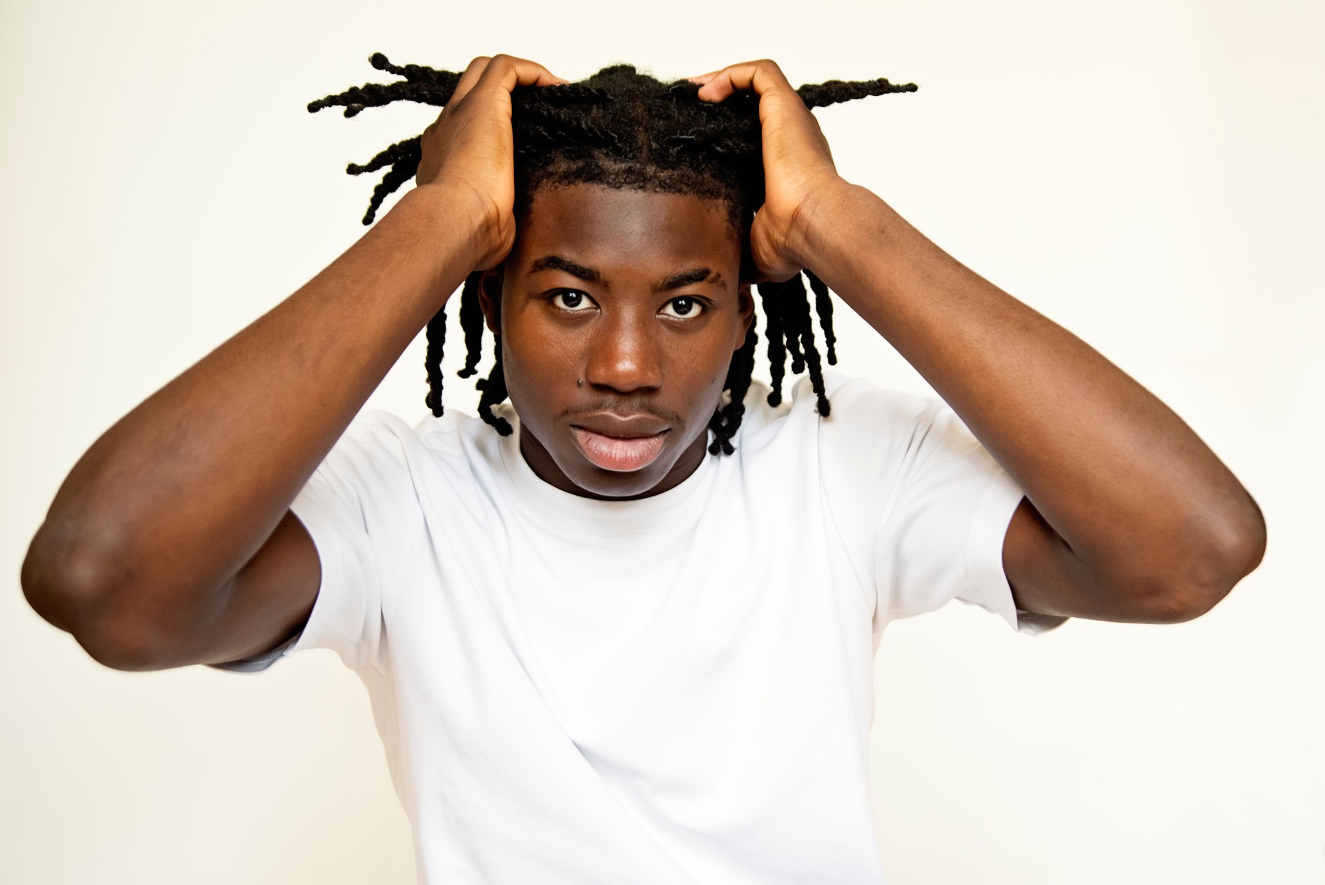 Portrait of stylish black young man on white background.